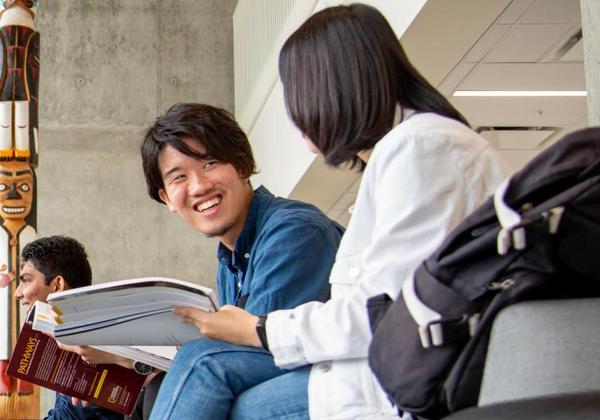Male and female students hanging out together inside a building