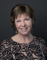 A smiling woman with short hair.