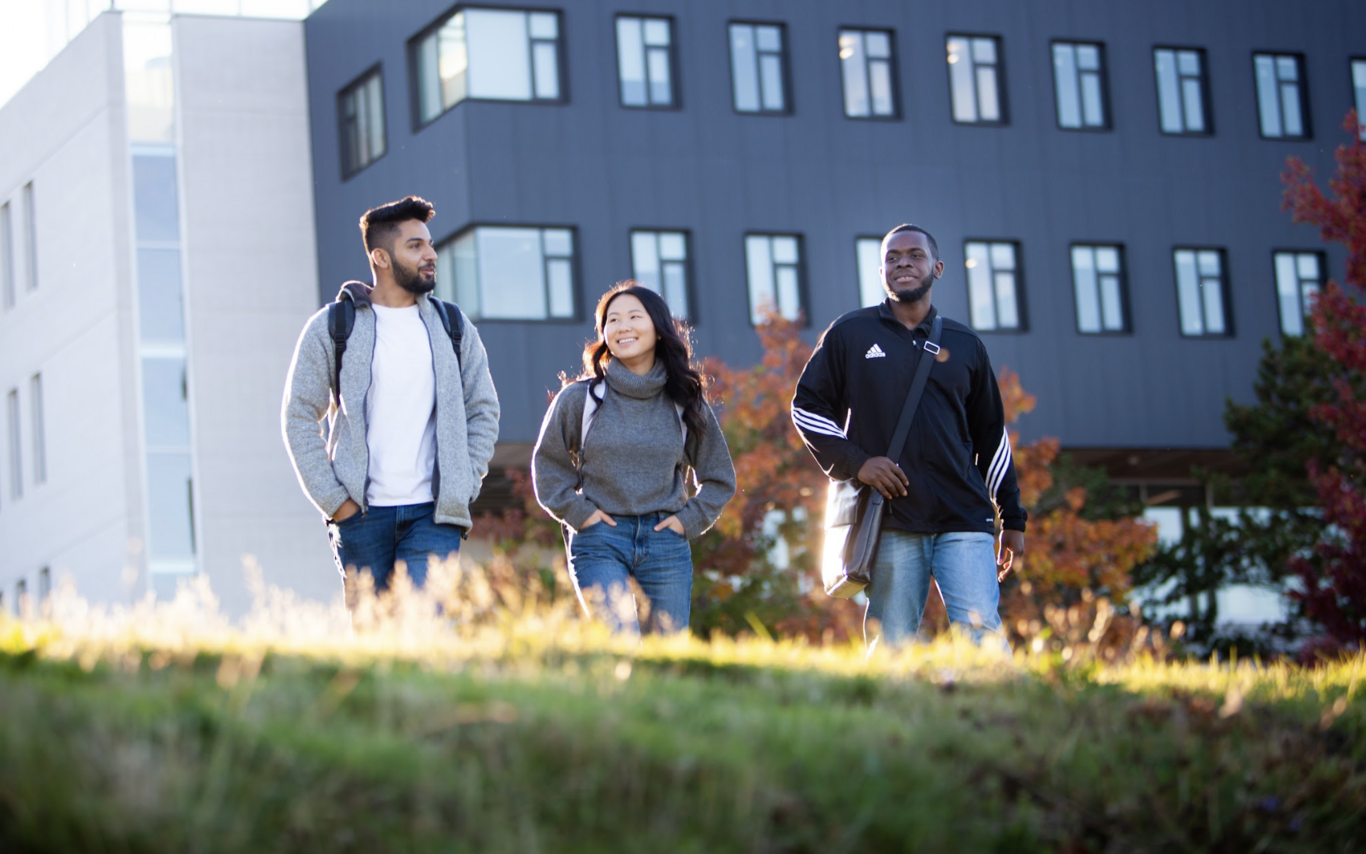 Three students walking and chatting together.